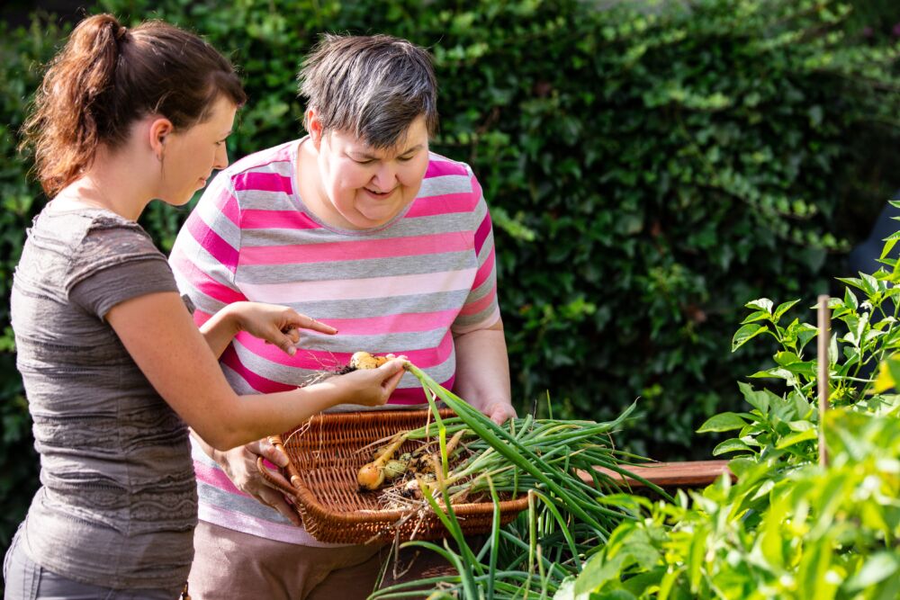 A woman and another woman in the garden.